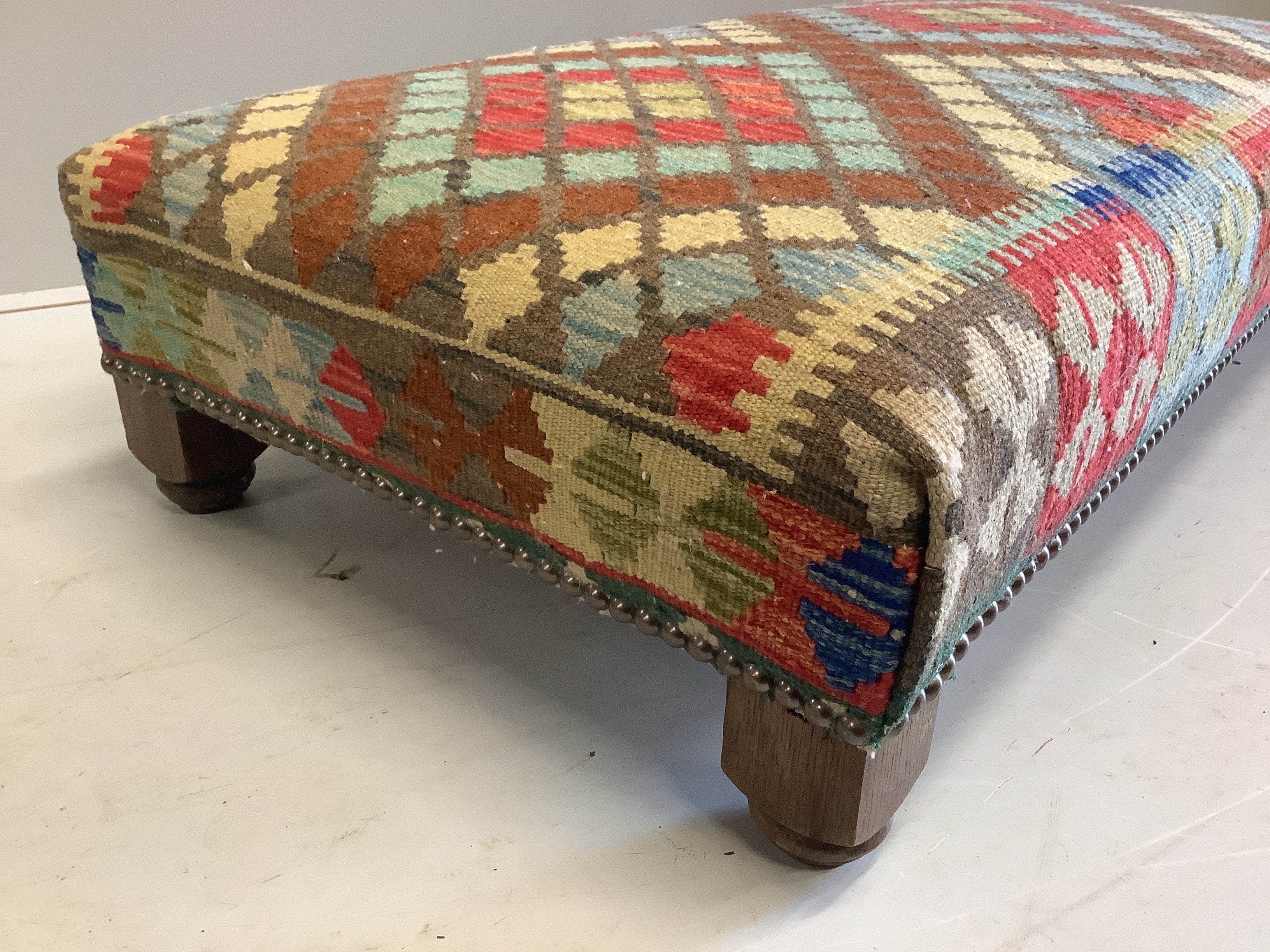 A rectangular Kilim footstool, on oak feet width 111cm, depth 60cm, height 25cm